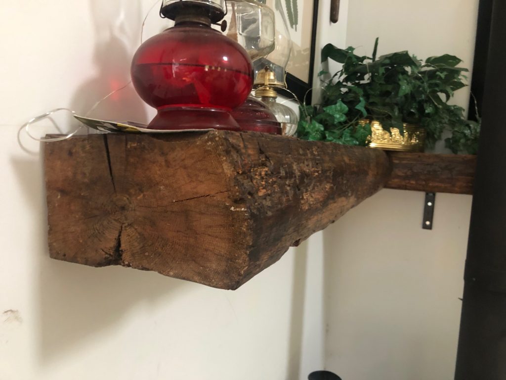 unsmoothed wood shelf holding decorations in a house